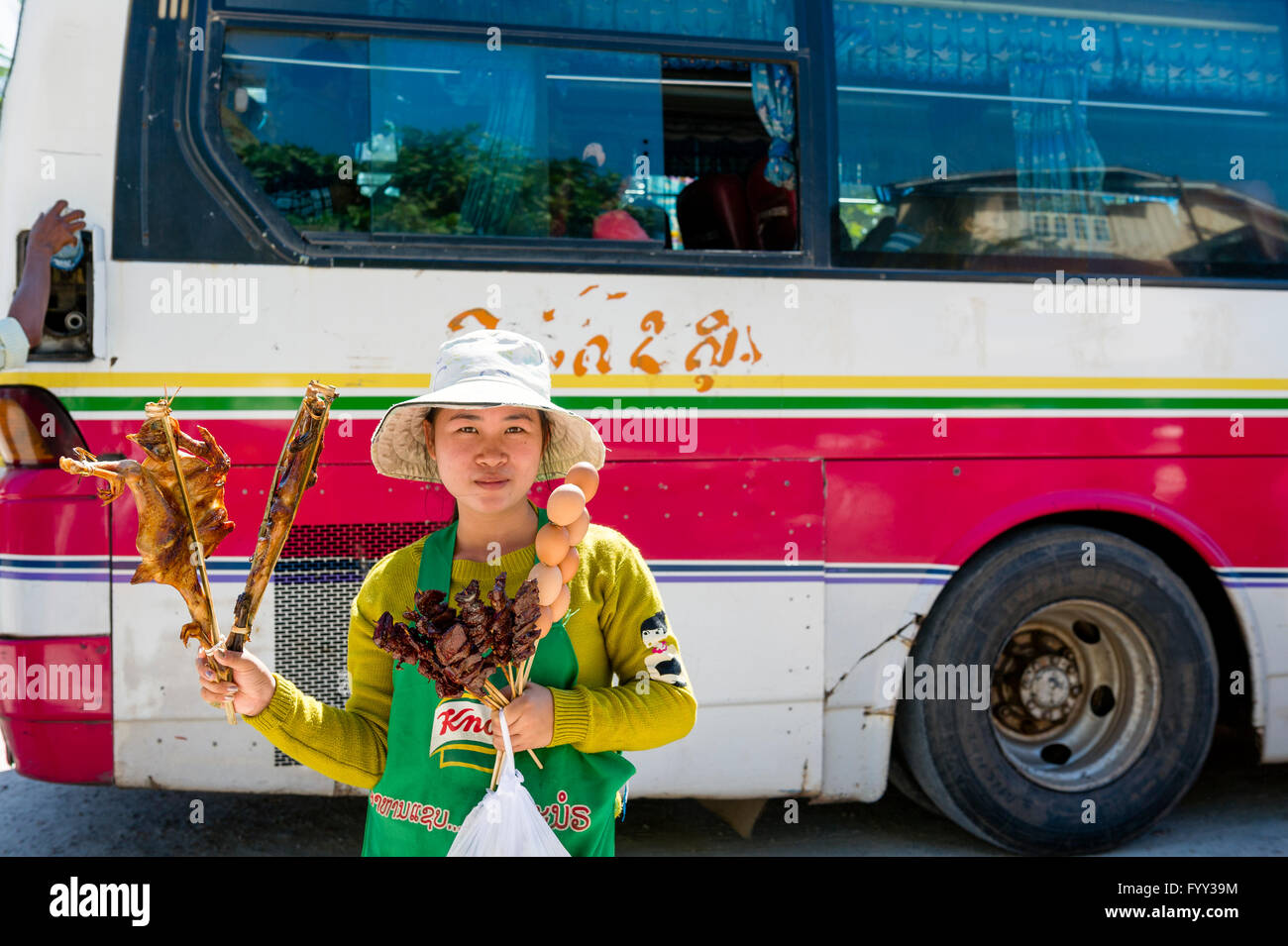 Asien. Süd-Ost-Asien. Laos. Provinz Khammuan. Thakhek. Frau Spieß an Bushaltestelle zu verkaufen. Stockfoto