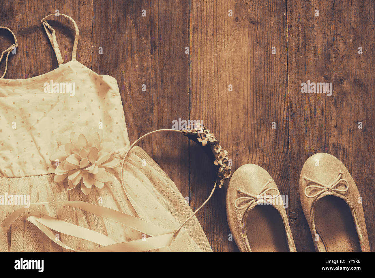 Vintage chiffon-Mädchen Kleid, Blumen Diadem neben Ballettschuhe auf hölzernen Hintergrund. Sepia-Stil Foto Stockfoto