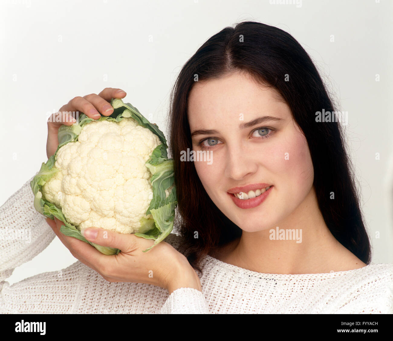 Eine Frau hält einen Blumenkohl im Inneren. Stockfoto