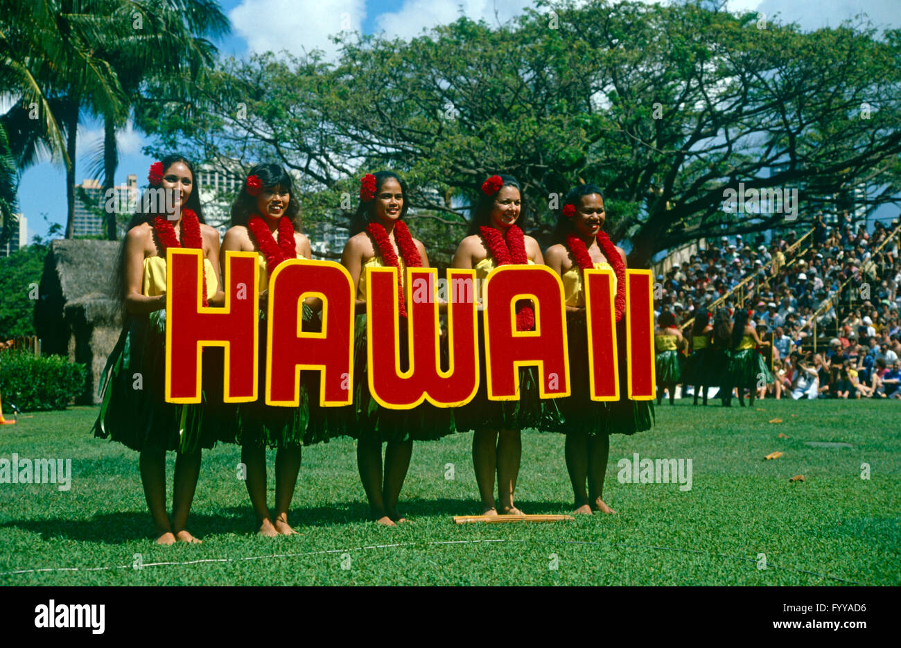 Fünf Hawaiian Hula-Mädchen hält eine "Hawaii" Zeichen, draußen. Stockfoto