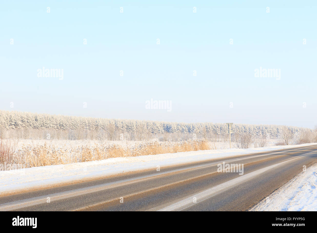 Winter-Straße durch verschneite Wiesen und Wälder Stockfoto