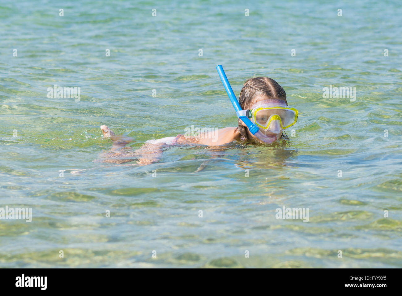 Mädchen schwebt über dem Wasser mit Maske und Schnorchel Stockfoto