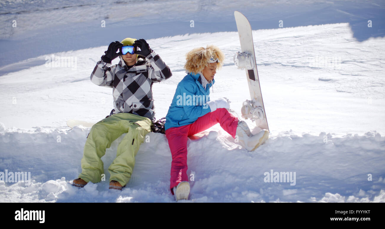 Junges Paar Vorbereitungen zum Snowboarden gehen Stockfoto