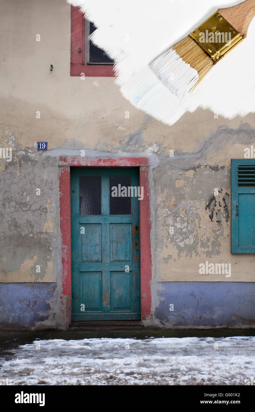 Illustrattion eines Pinsels mit weißer Farbe Malerei über ein altes Haus Stockfoto