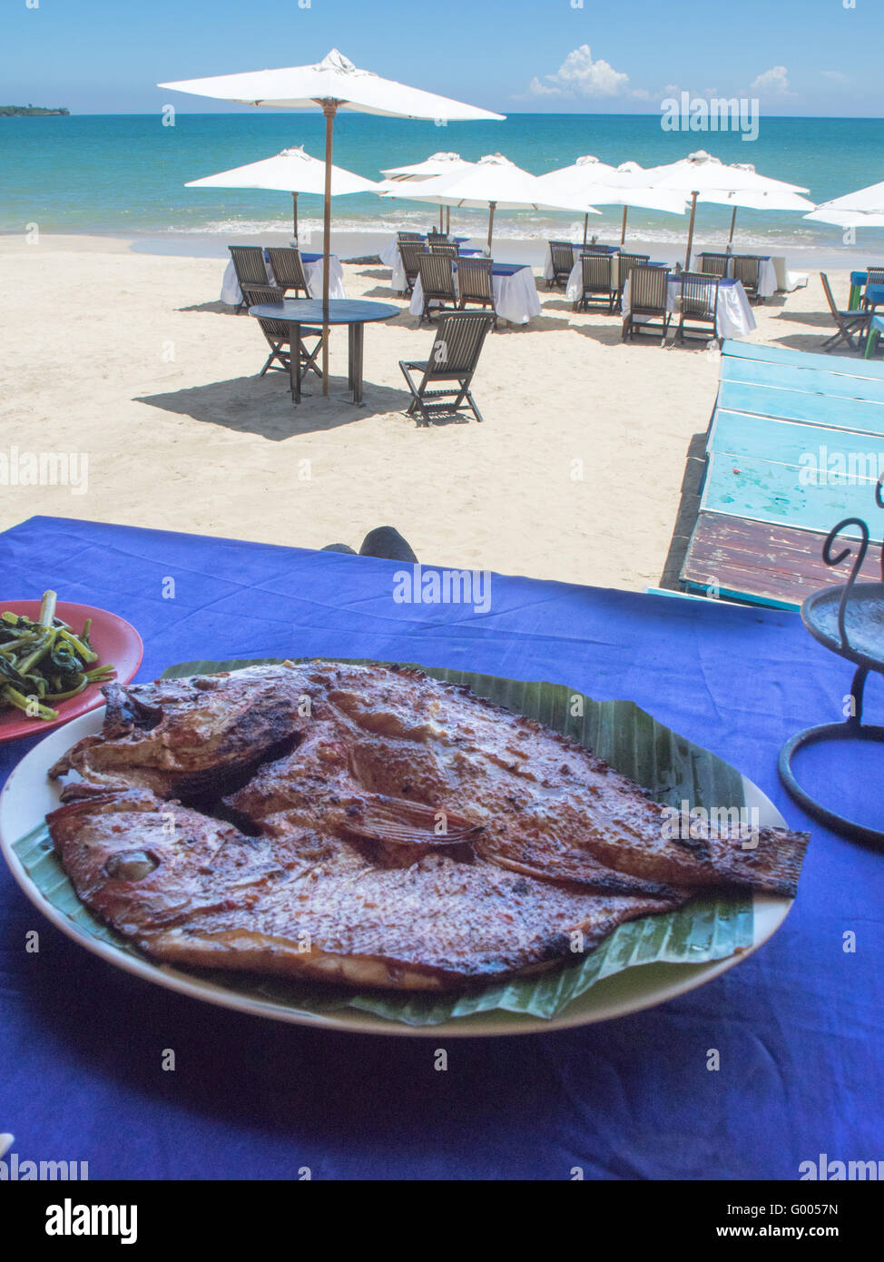 Chargrilled Snapper Fisch auf eine weiße Platte und Banane lassen in einem Restaurant am Strand präsentiert. Stockfoto
