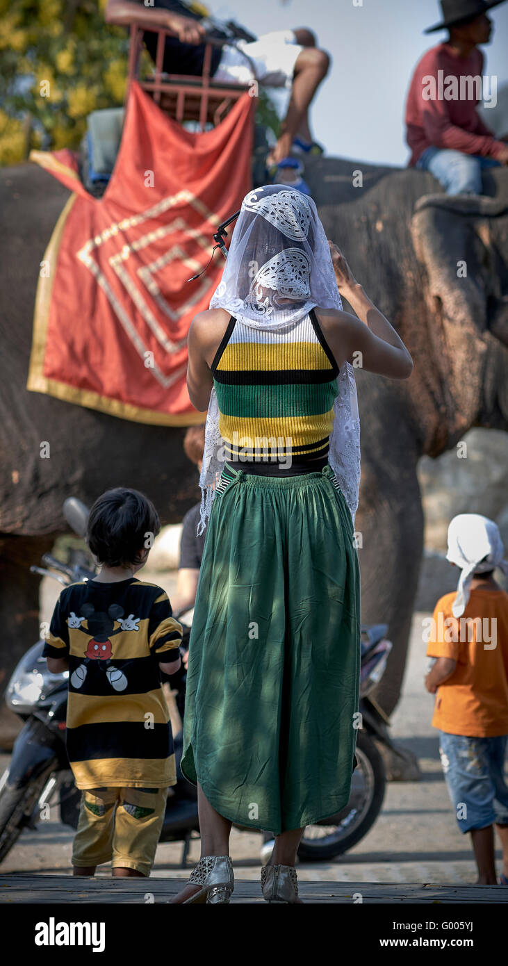 Thailand Tourist. Frau fotografiert einen vorbeiziehenden Elefanten und Mahout. S. E. Asien. Stockfoto