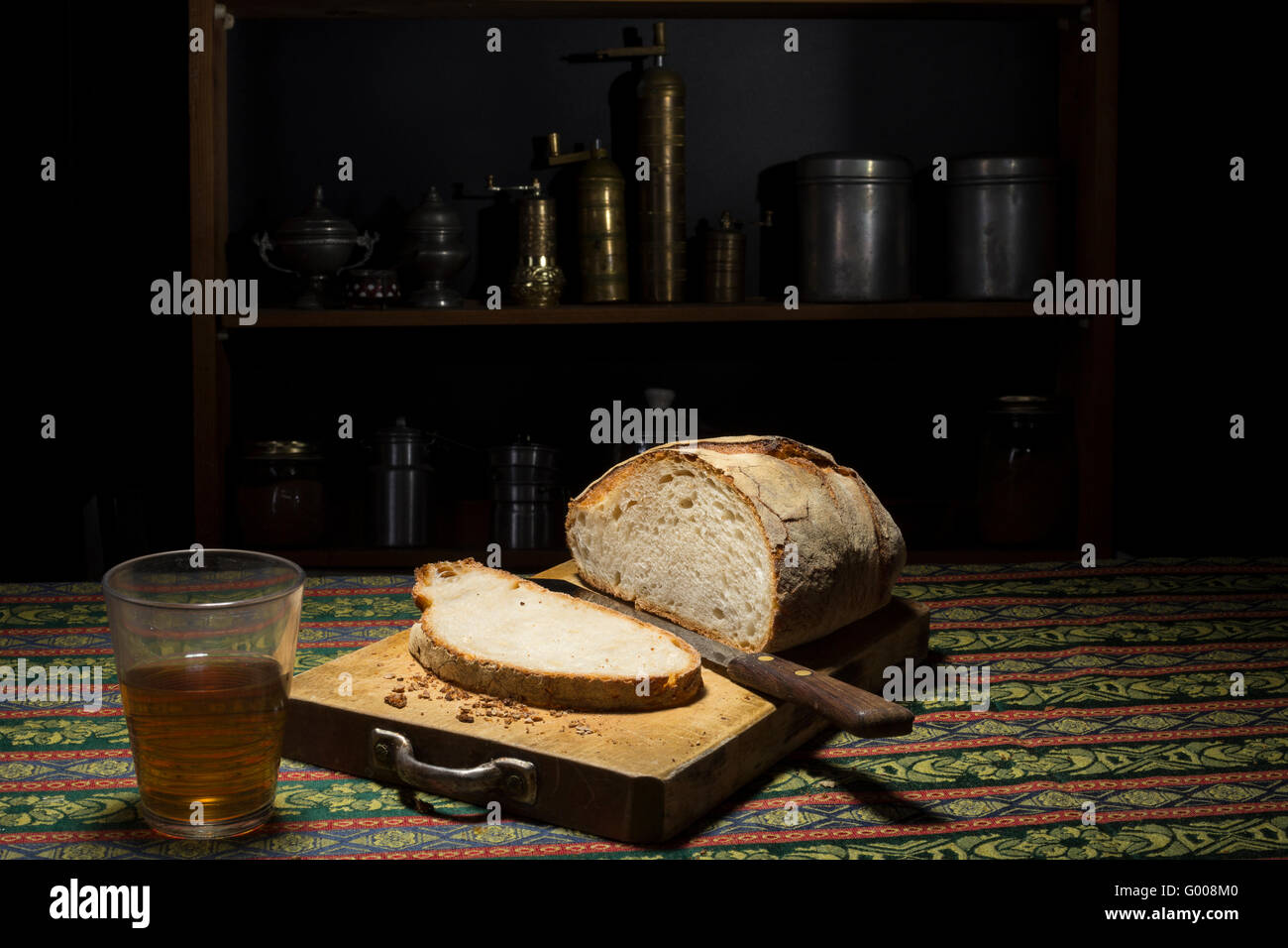 Laib und italienischen Brot in einem Schneidbrett in einer dunklen Küche Stockfoto