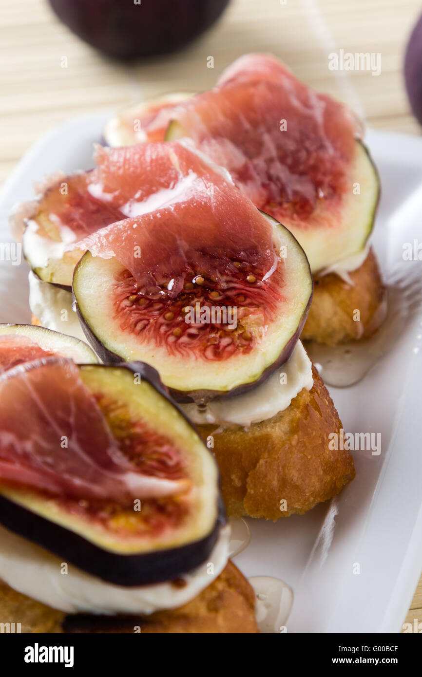 Feigen mit Käse, Schinken und Honig Stockfoto