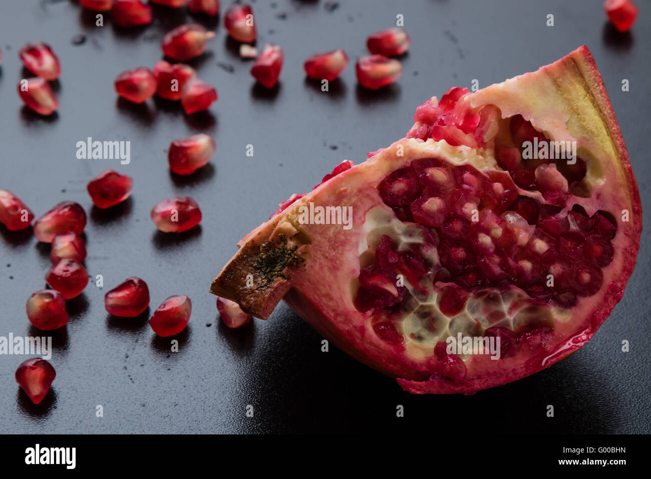 Granatapfel auf einem schwarzen Tisch Stockfoto