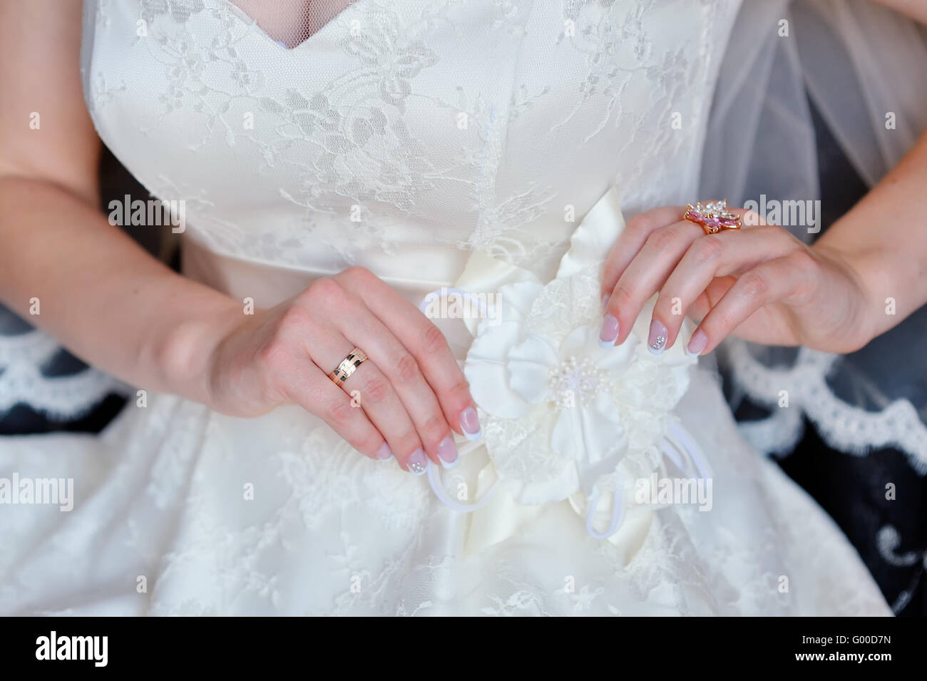 Braut passt weißen Schleife an ihrem Kleid Stockfoto