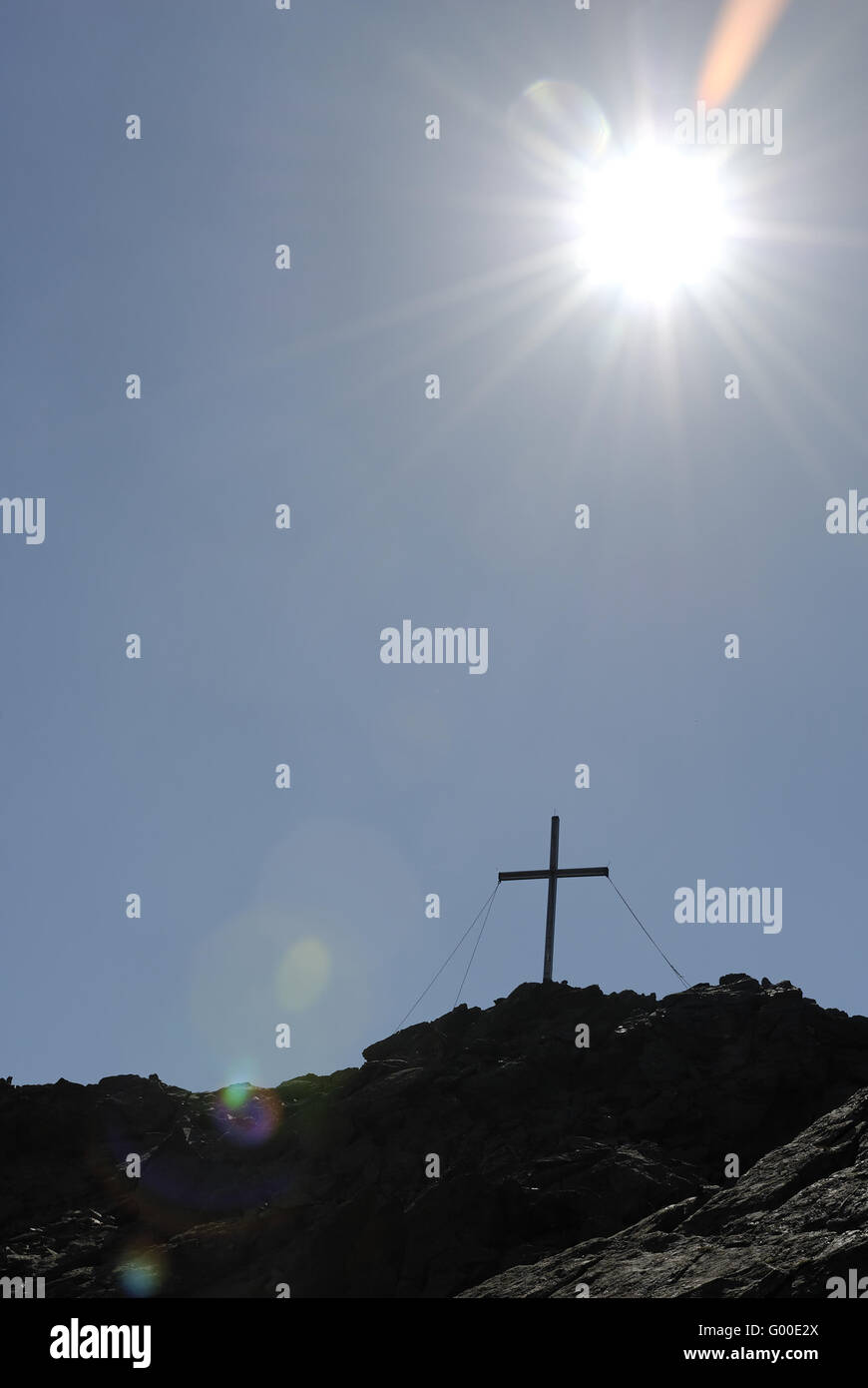 Gipfelkreuz mit blauen Himmel und Sonne Stockfoto
