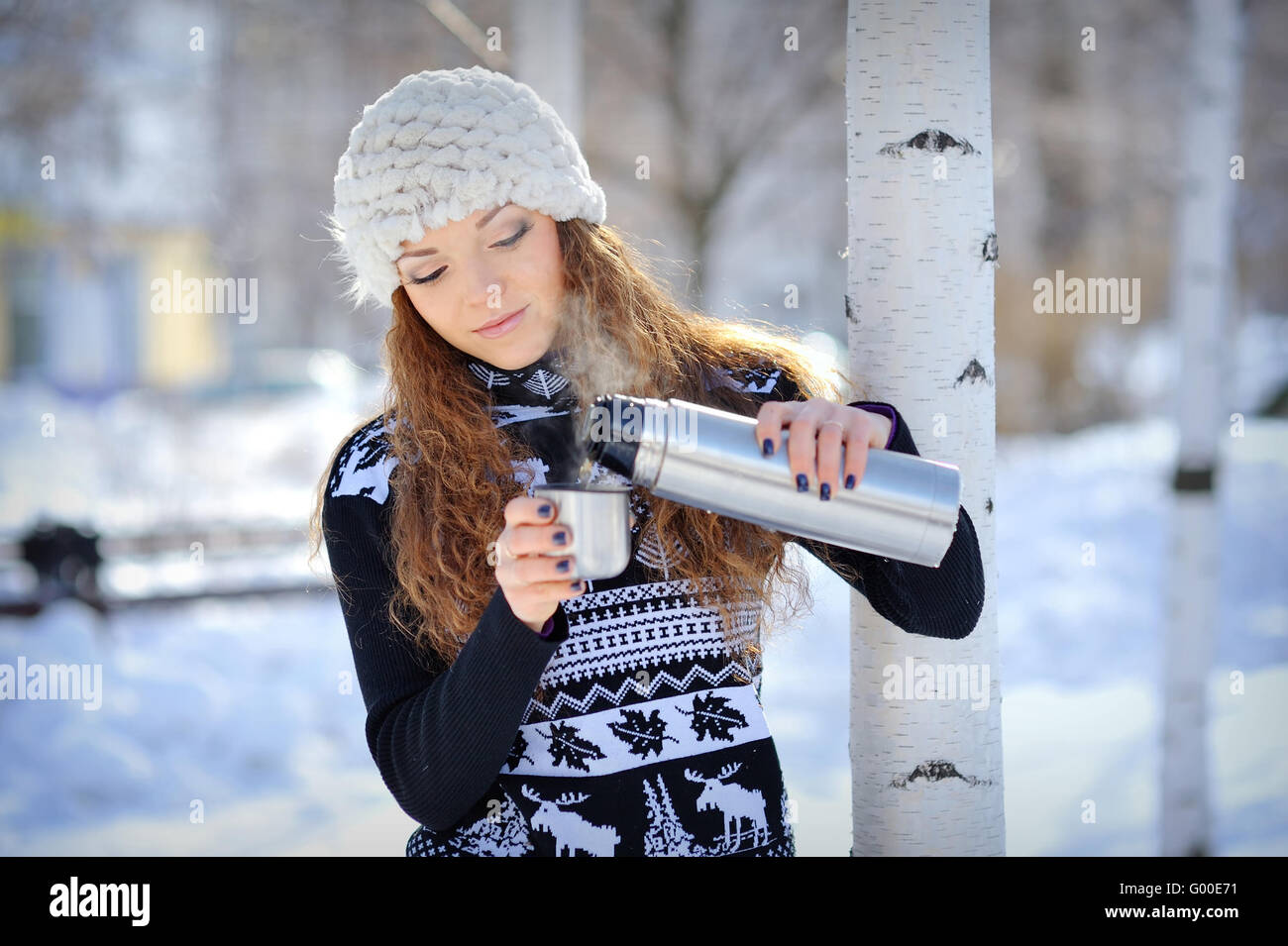 schöne Mädchen mit Thermoskanne und Tasse heißen Tee in frostigen Wintertag Stockfoto