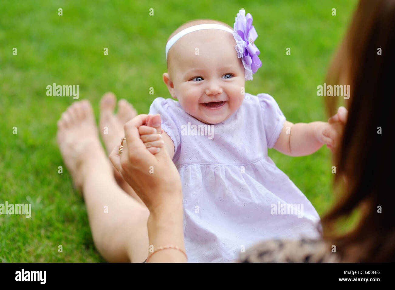 Mutter Holding niedlichen Kind in Händen. kleines Baby liegend in übergeordneten Stockfoto