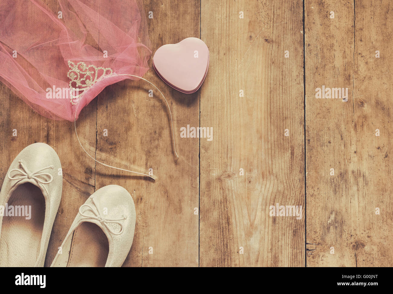 des Mädchens Diamant Diadem mit rosa Chiffon vail neben Ballettschuhe auf hölzernen Hintergrund. Sepia-Stil gefilterten Bild Stockfoto