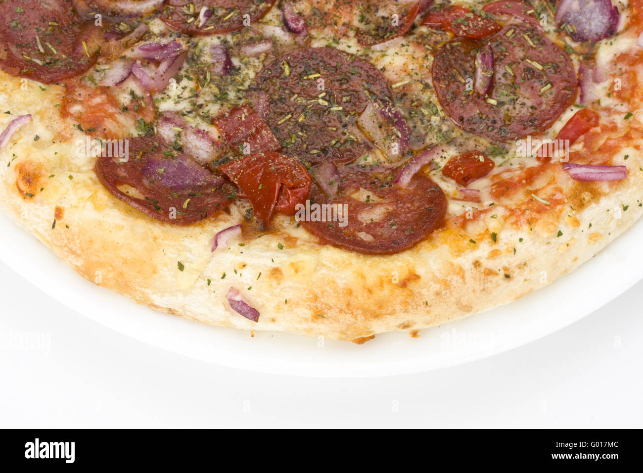 eine Pizza auf einem weißen Teller über hellen grauen Hintergrund Stockfoto