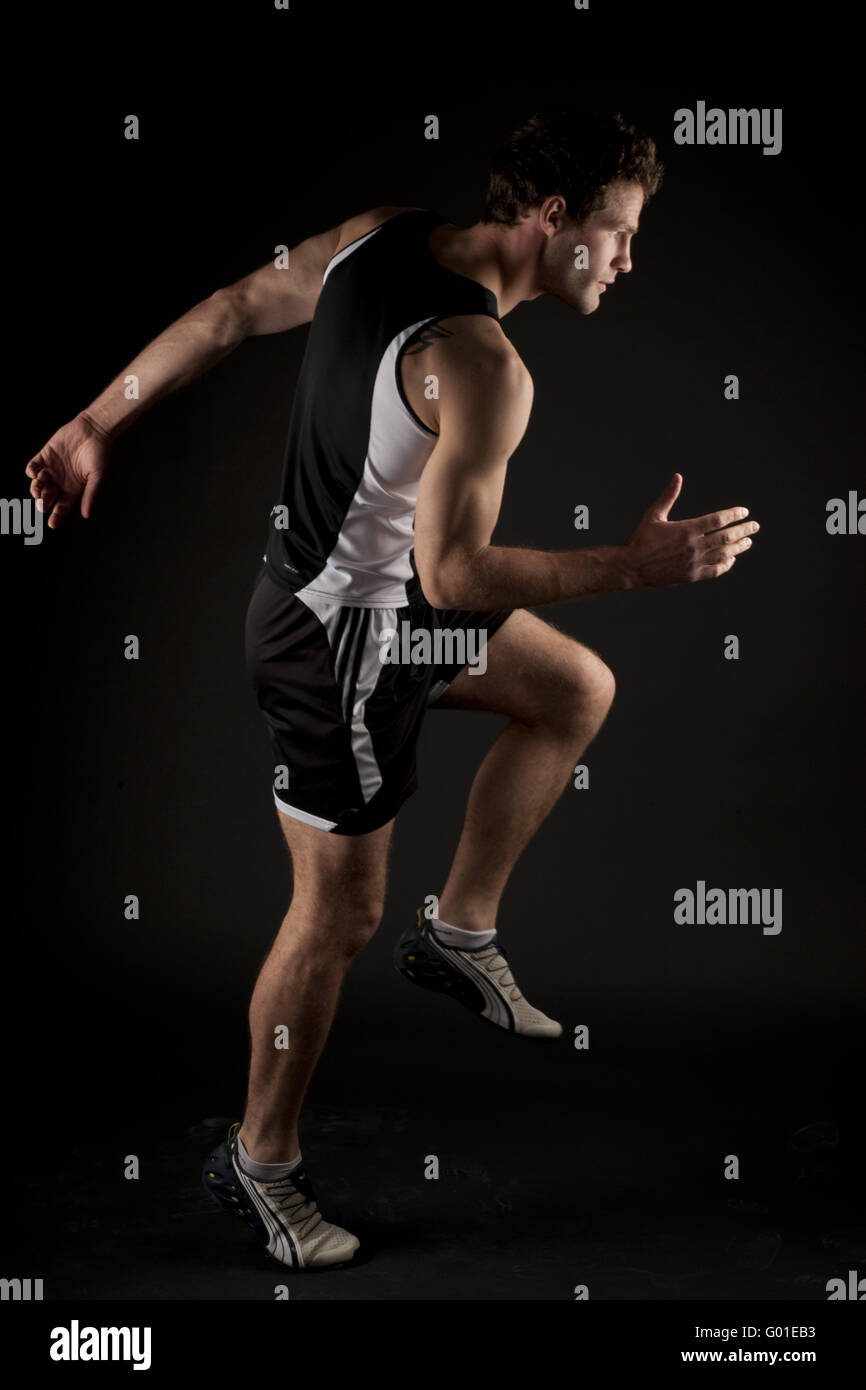 körperlich fit Mann läuft auf schwarzem Hintergrund isoliert Stockfoto
