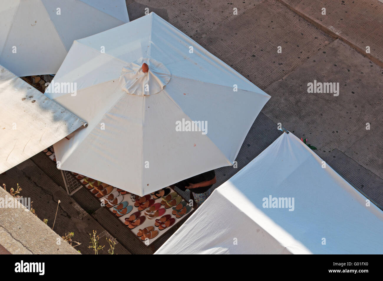 Menorca, Balearen, Spanien, Europa: Weißer Schirm und steht von Schuhen und Lederwaren im handwerkermarkt von Ciutadella Stockfoto