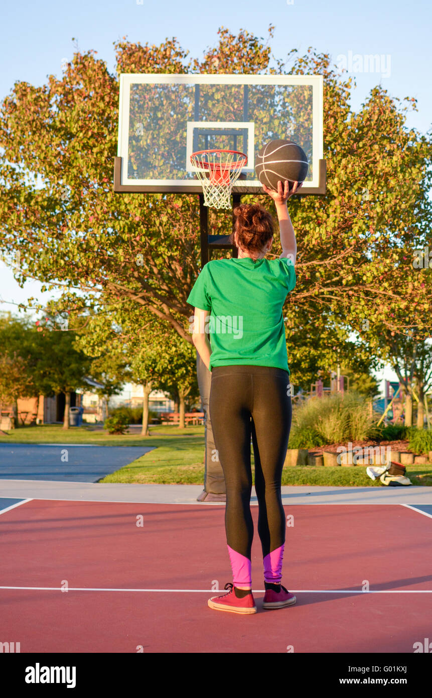 Junge Frau auf den Korb zu schießen. Basketball-Spieler Stockfoto
