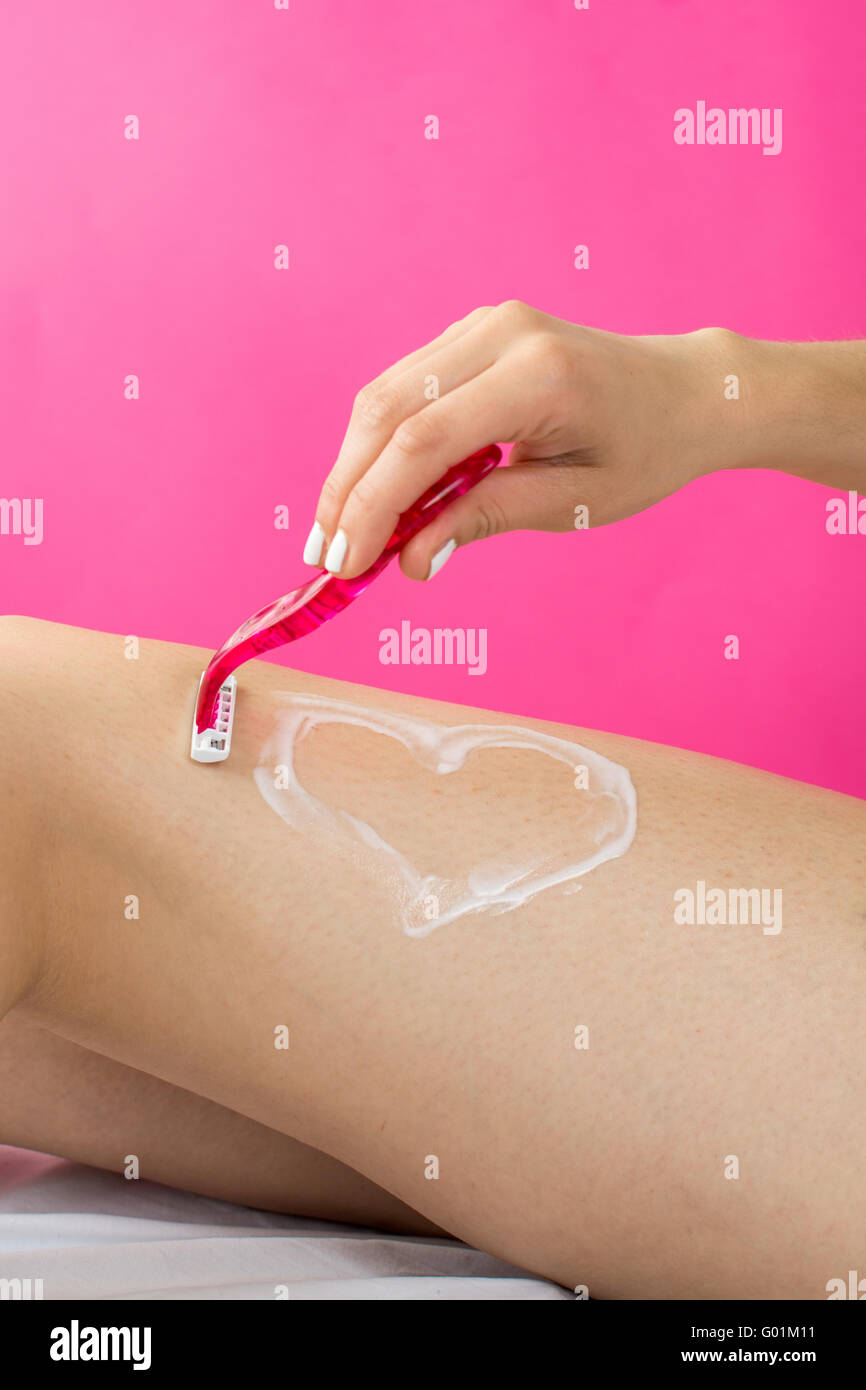Frau rasieren ihr Bein mit Herzform aus Schaumstoff gefertigt Stockfoto