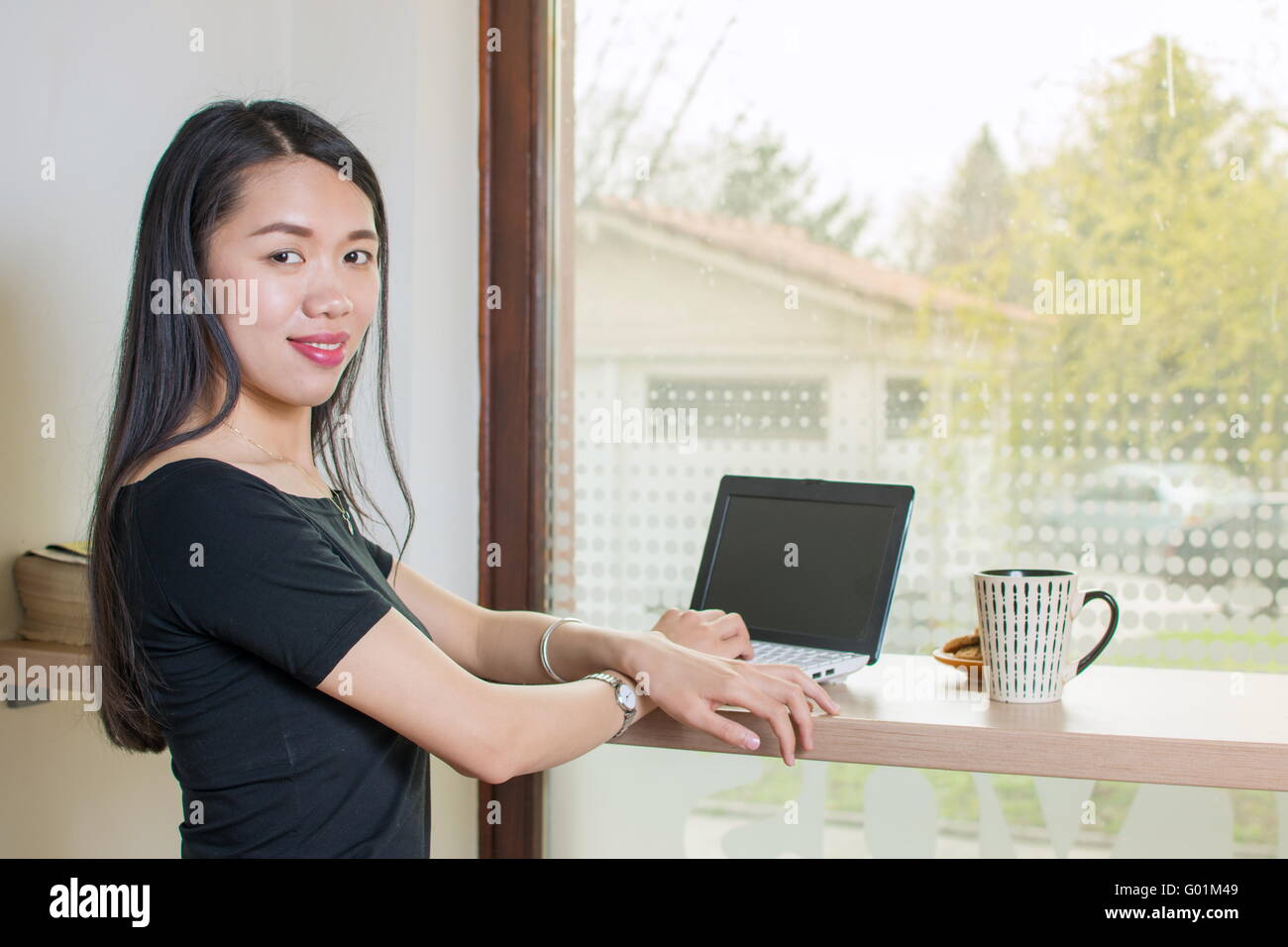 Junge asiatische Frau mit Laptop Stockfoto