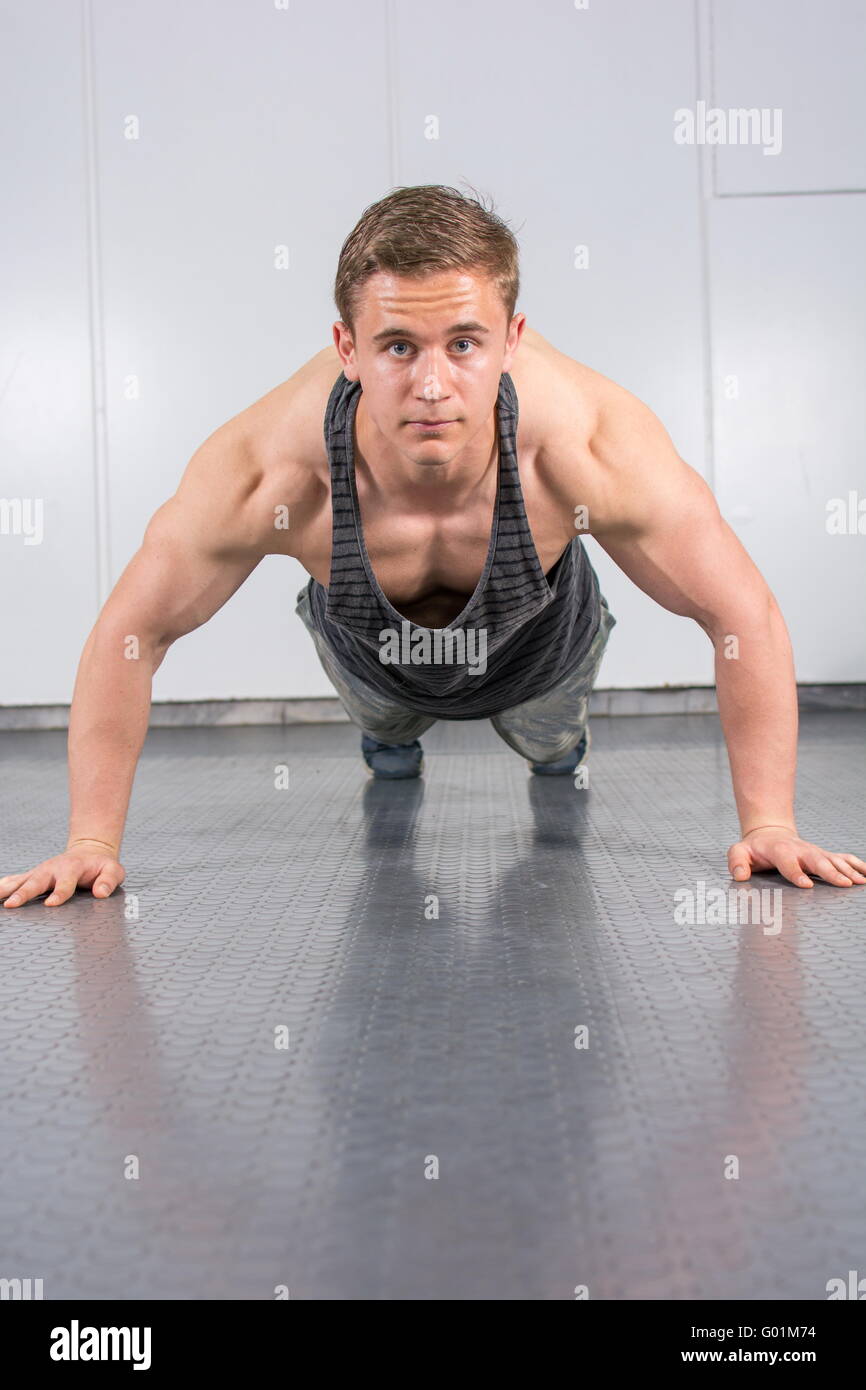 Junger Mann ausführen Push-Ups in der Turnhalle Stockfoto