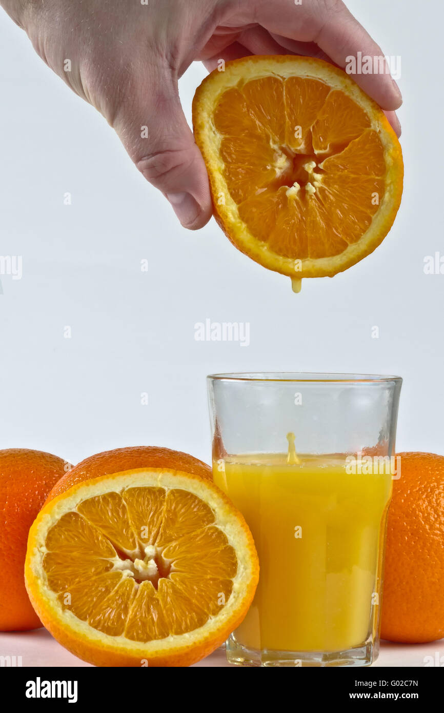 O-Saft tropfte in Glas von Orangenfrucht Stockfoto