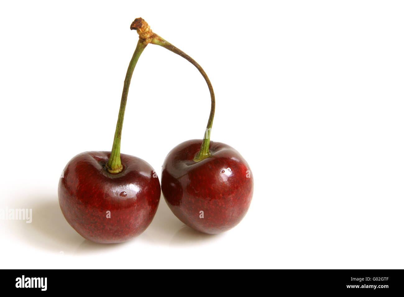 Zwei rote Kirschen auf einem weißen Hintergrund isoliert Stockfoto