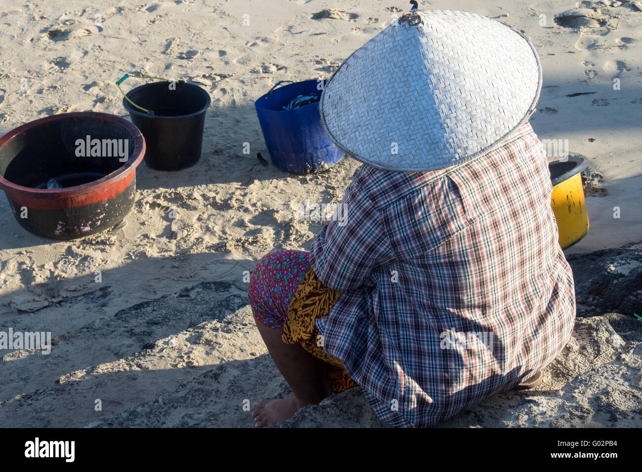 Eine Frau, Verkauf von Fischen am Strand von Jimbaran Bay, Bali. Stockfoto