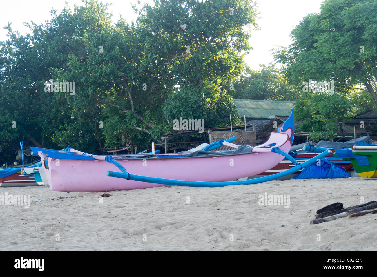 Ein rosa Fischerboot in Jimbaran Bay, Bali. Stockfoto