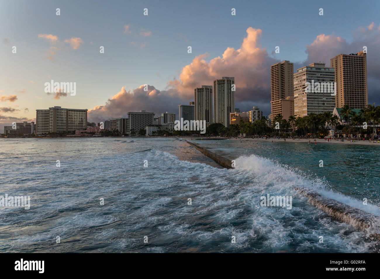 Kuhio Beach Park in Waikiki bei Sonnenuntergang mit Blick auf die Hotels. Stockfoto