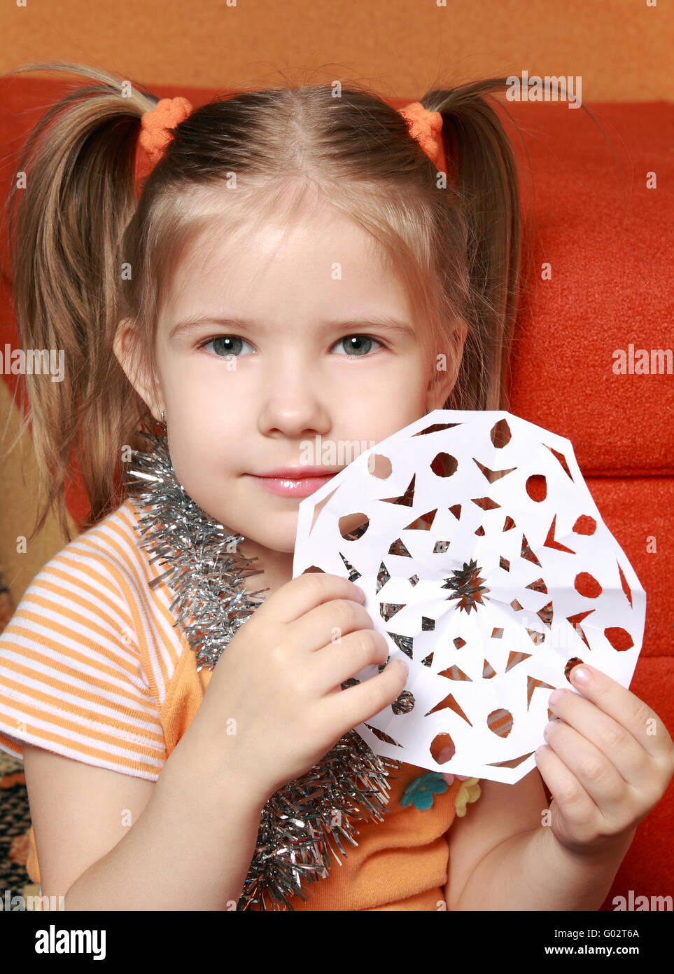 Das vier-jährigen Mädchen schneiden Sie eine Schneeflocke aus einer Stockfoto