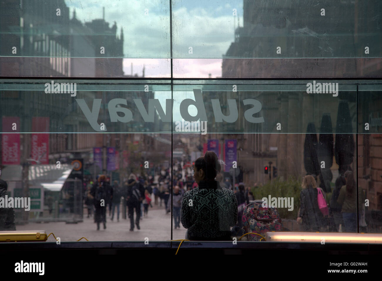 junges Mädchen mit Tasche sitzt auf Straße Bank u-Bahn Fenster Stockfoto