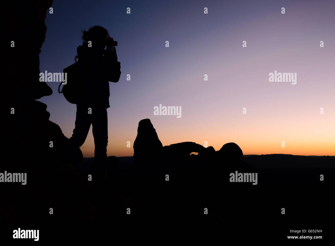 Frau Reisenden Foto zu schießen, bei Sonnenuntergang, Silhouette. Outdoor-Aktivitäten Stockfoto