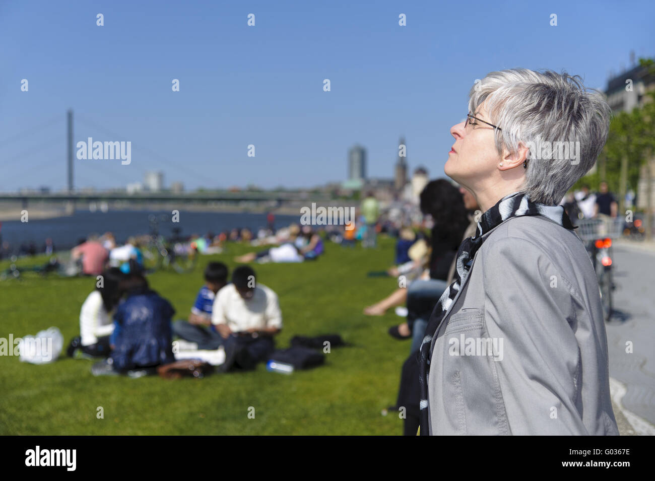 Frau genießt die Frühlingssonne an den Rhein Stockfoto