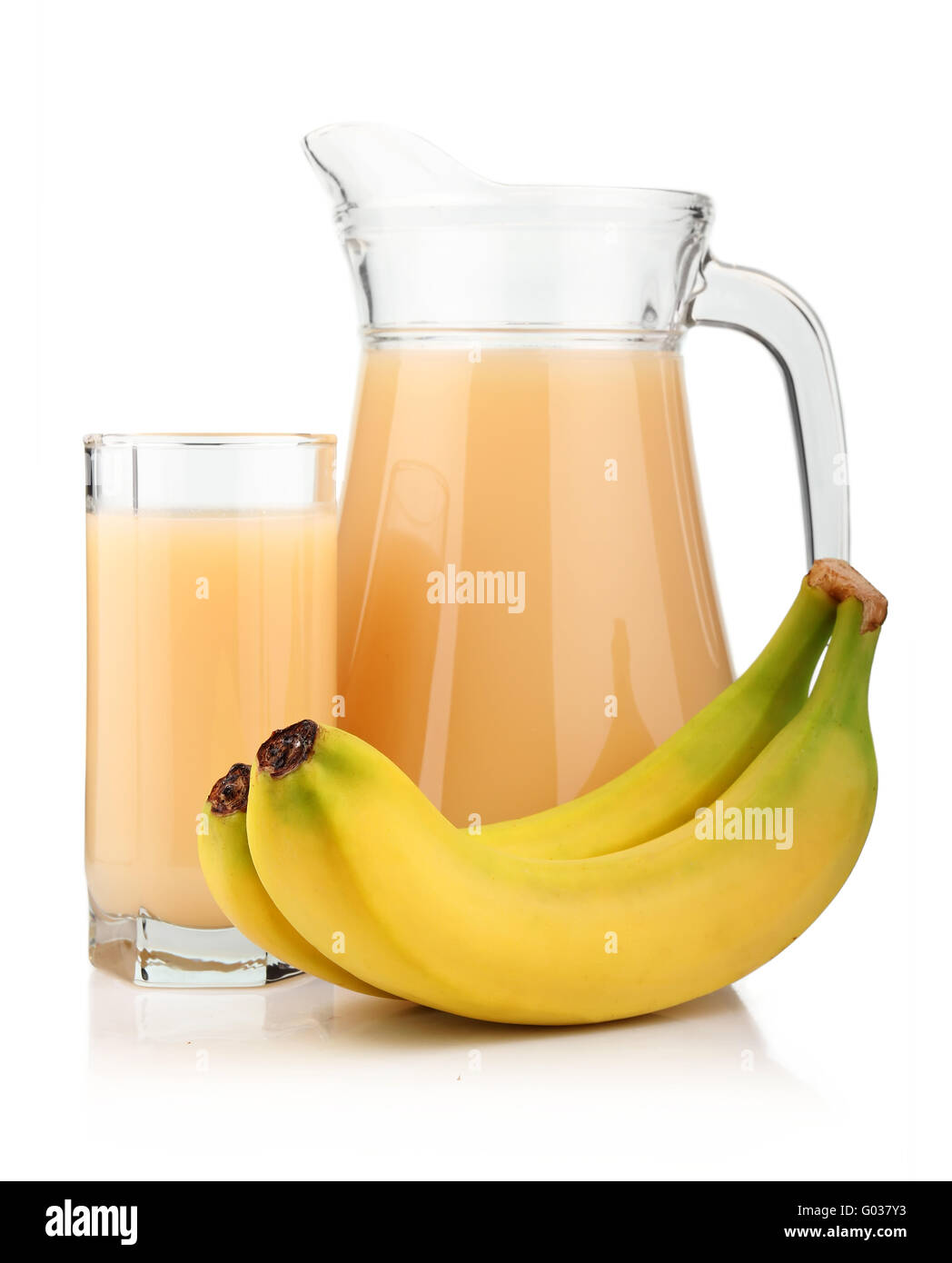 Volles Glas und Krug mit Bananensaft und Früchten isoliert Stockfoto