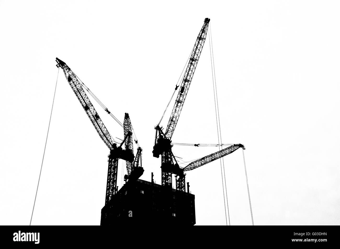 Schwarz / weiß-Silhouette-Kran an der Spitze einer unter Bau Gebäude Stockfoto