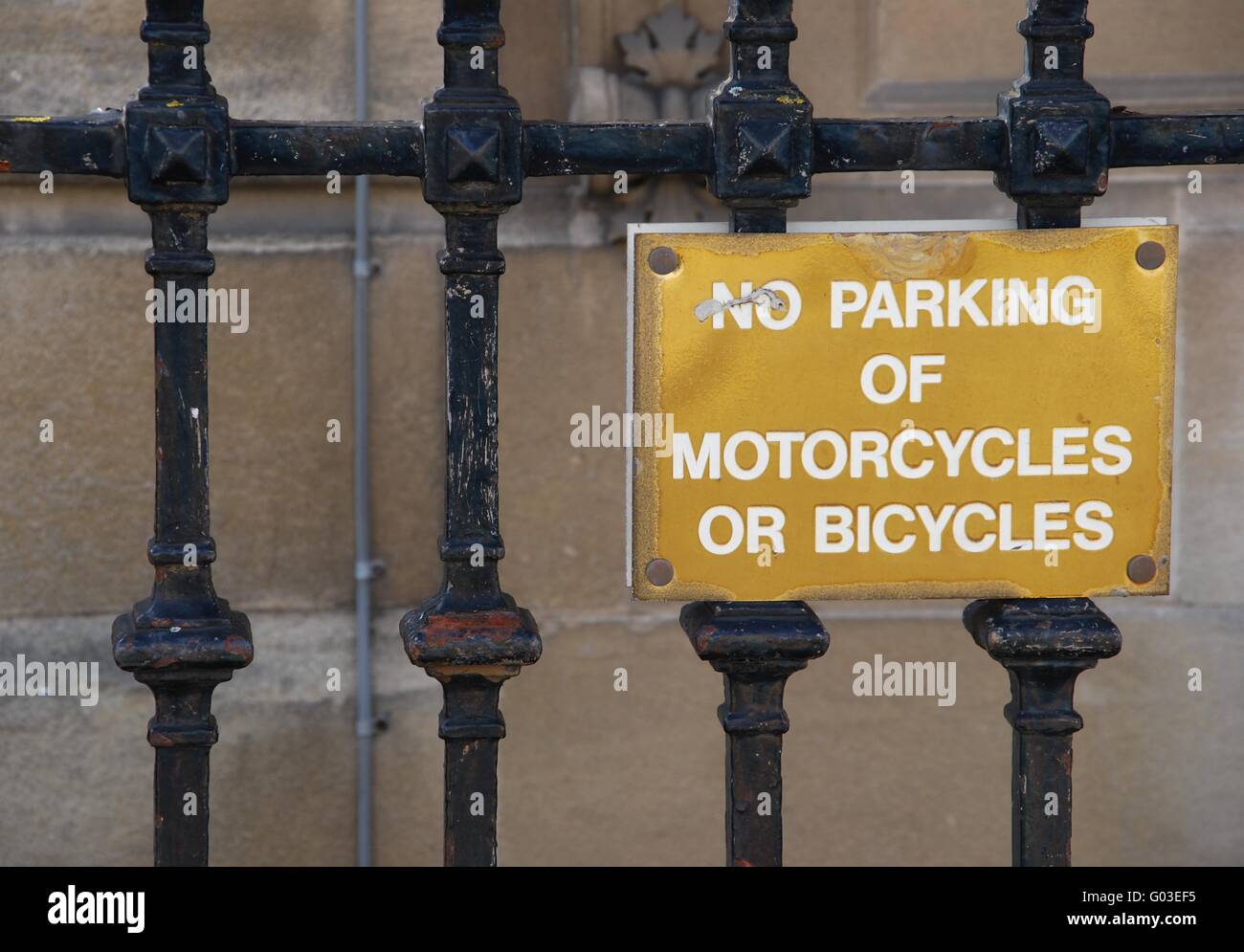 kein Parkplatz für Motorräder oder Fahrräder goldenen Schild auf einem metallischen Zaun hängen Stockfoto