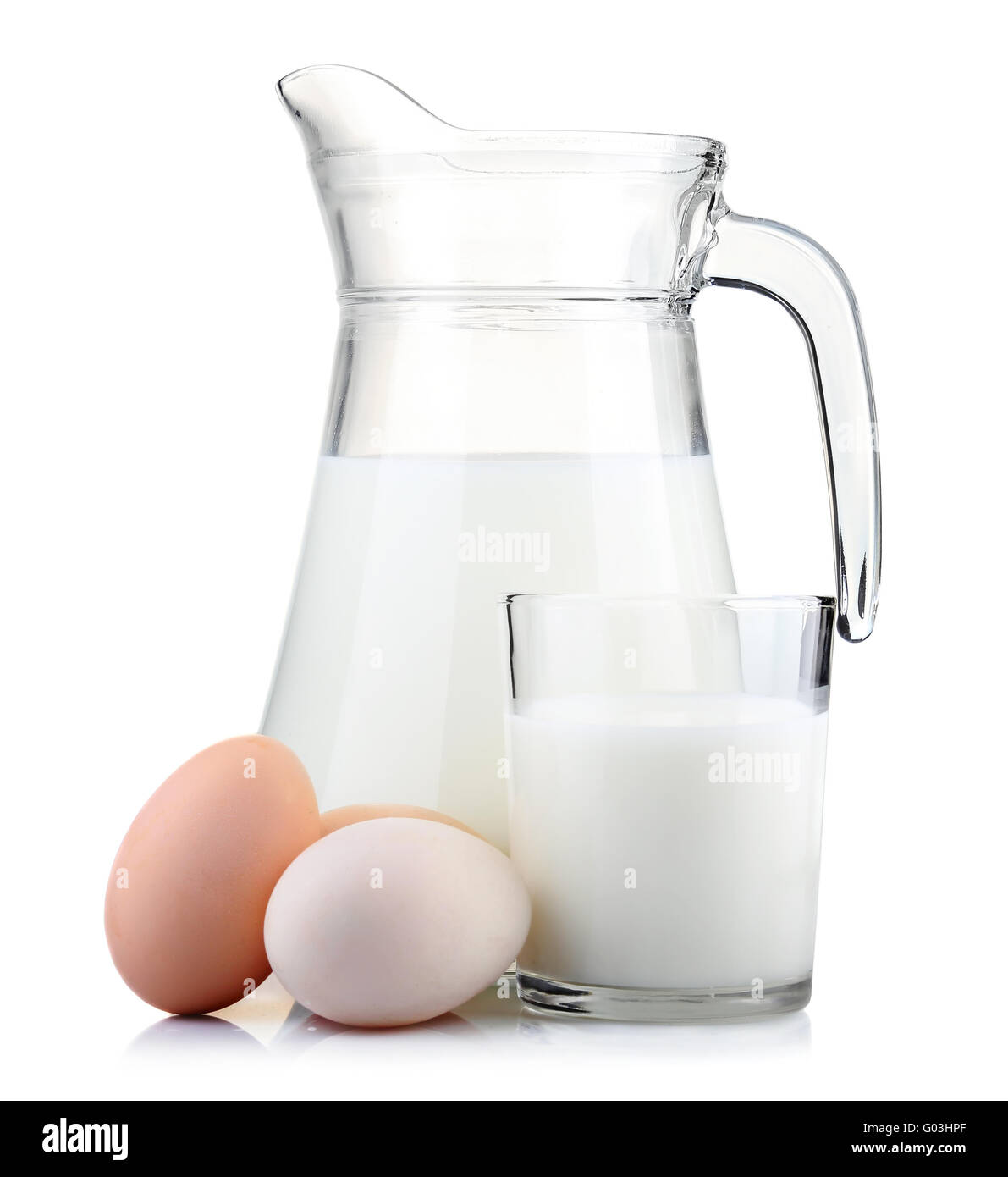 Krug mit Milch und Glas mit Eiern isoliert auf weiss Stockfoto