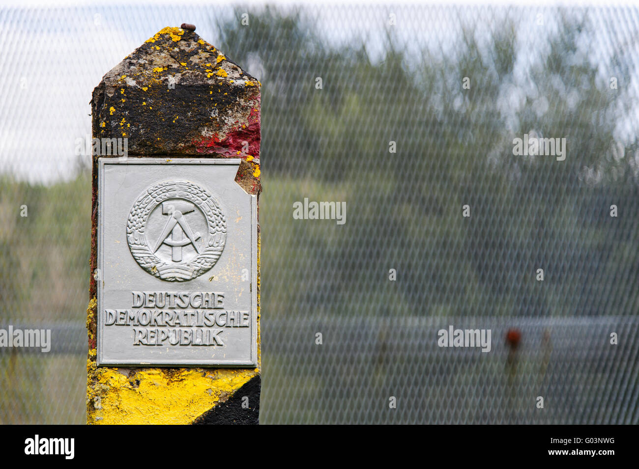 alte Grenze post vor einem Grenzzaun entlang t Stockfoto