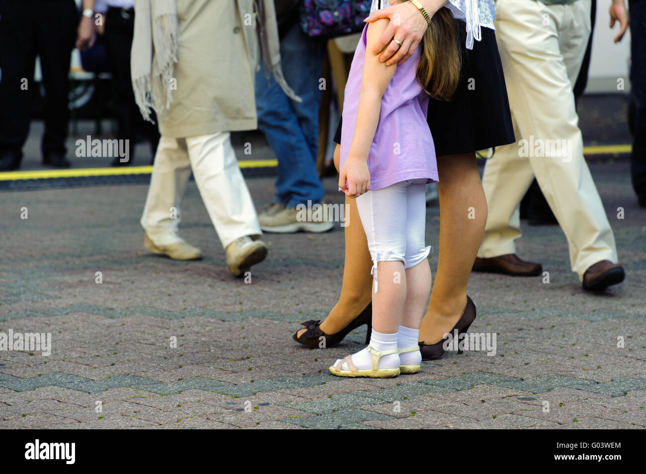 Die Beine von mehreren Personen an einer befahrenen Straße Stockfoto