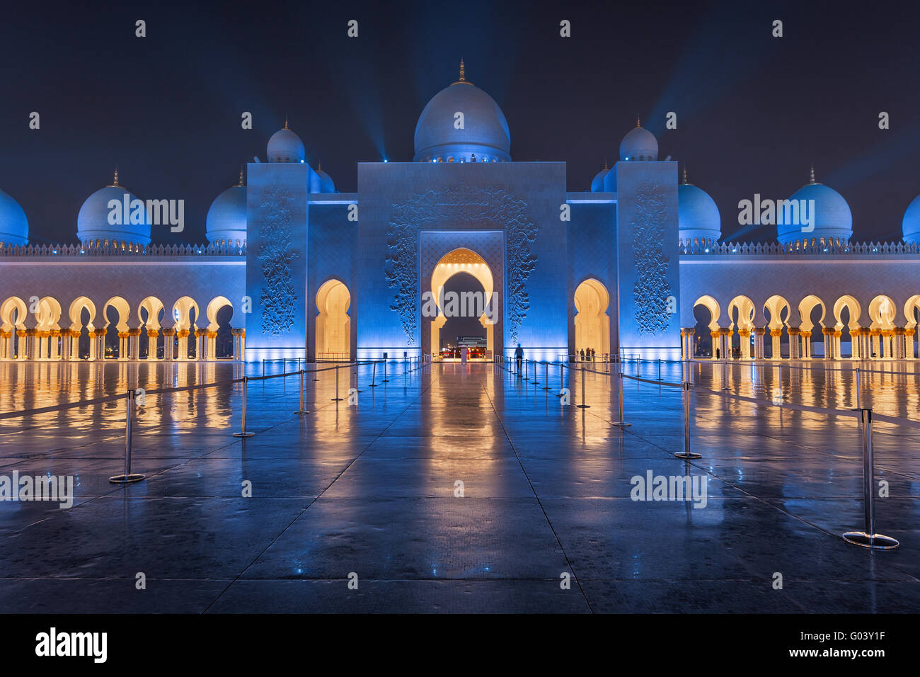Sheikh Zayed Grand Moschee bei Nacht bedeckt mit schönen blauen Lichtern und Lichtstrahlen Stockfoto