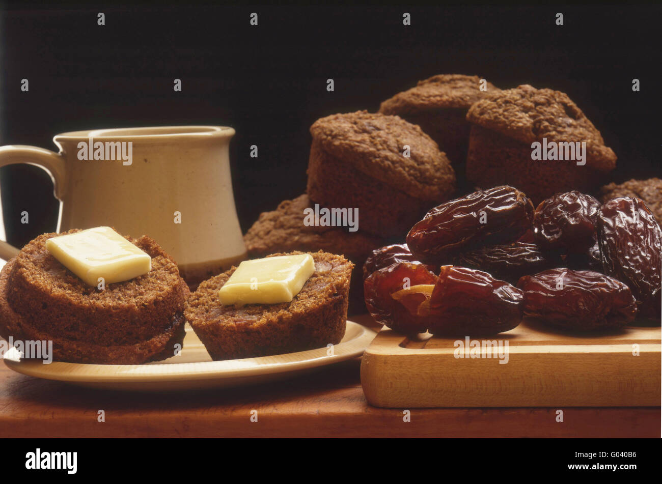 Frühstück mit Butter frisch gebackene Kleie-Muffins mit Kaffee geschnitten und getrocknete Datteln. Stockfoto