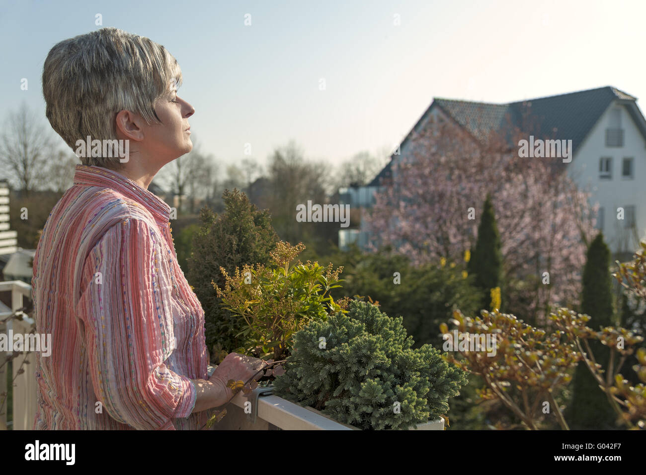 Frau stehend auf dem Balkon und genießen Sie den Morgen Stockfoto