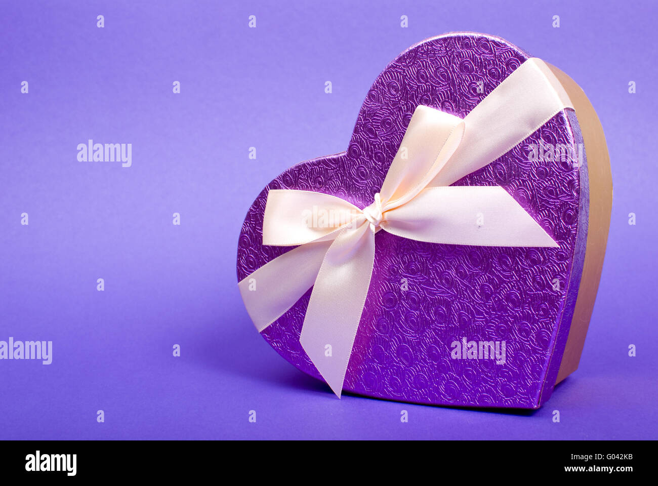 Einziges Herz Geschenkbox mit Schleife auf blauem Hintergrund. Stockfoto