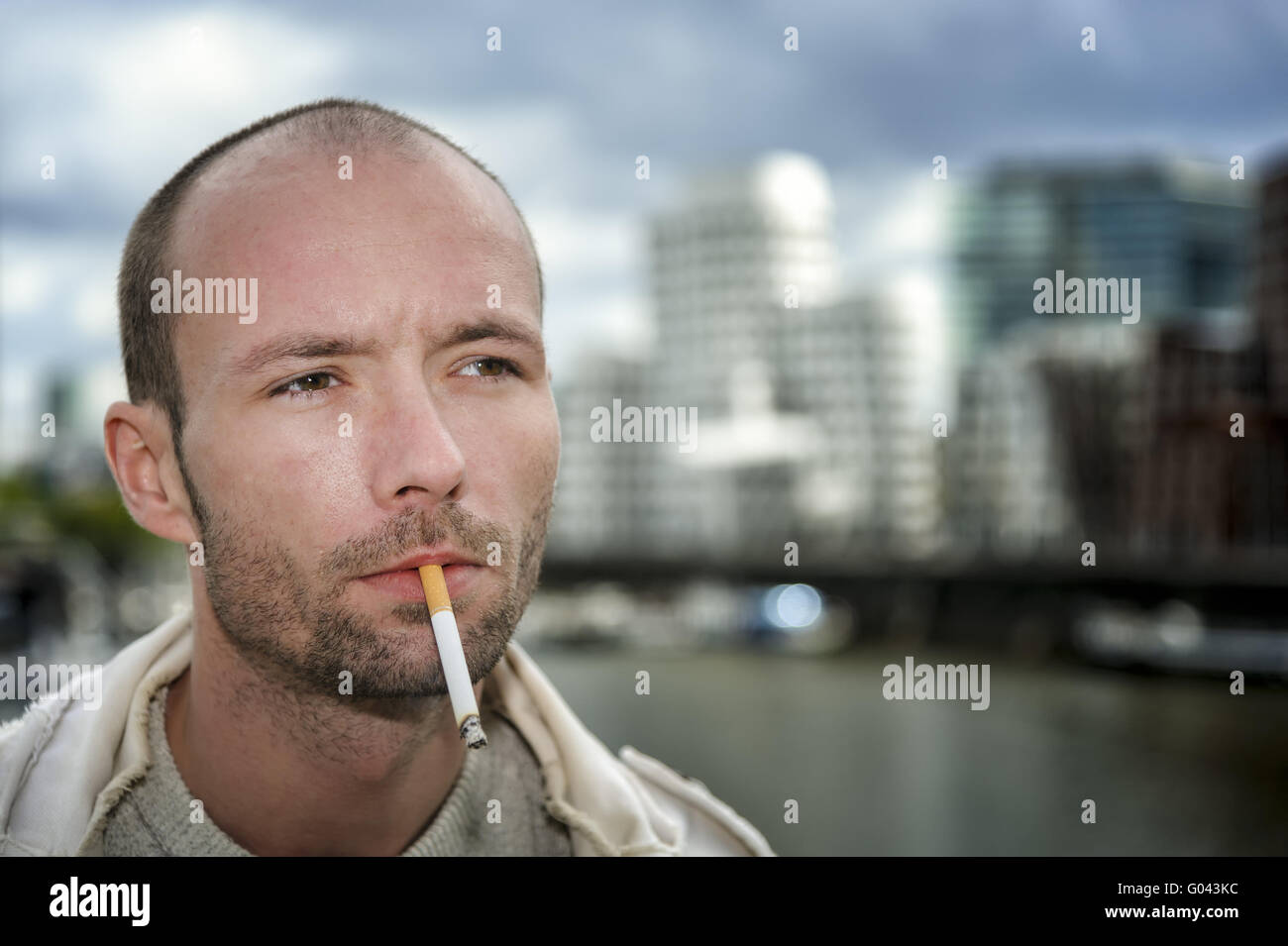 junger Mann mit einer Zigarette im Medienhafen Düs Stockfoto