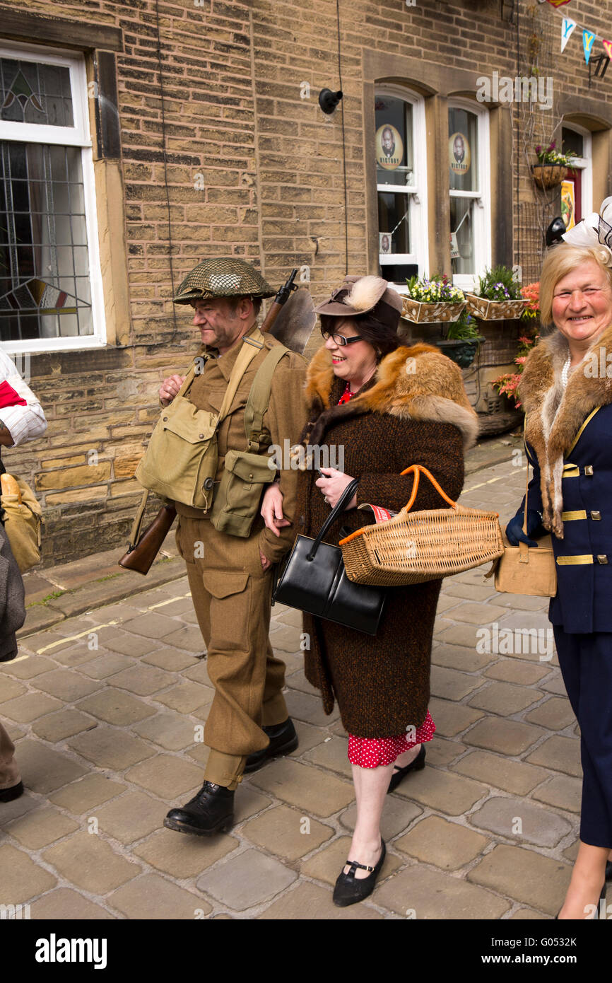 Großbritannien, England, Yorkshire, Haworth 40er Jahre Wochenende, Main Street, paar in Kriegszeiten Kostüm zu Fuß bergab Stockfoto