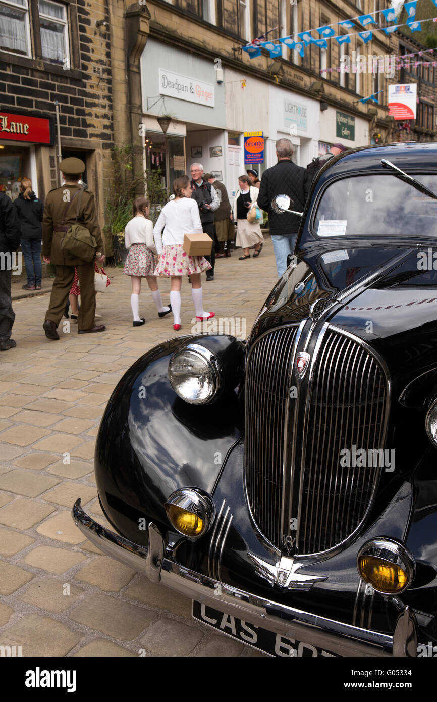 Großbritannien, England, Yorkshire, Haworth 40er Jahre Wochenende, Main Street, Besucher vorbei an amerikanischen Plymouth-Motorwagen Stockfoto