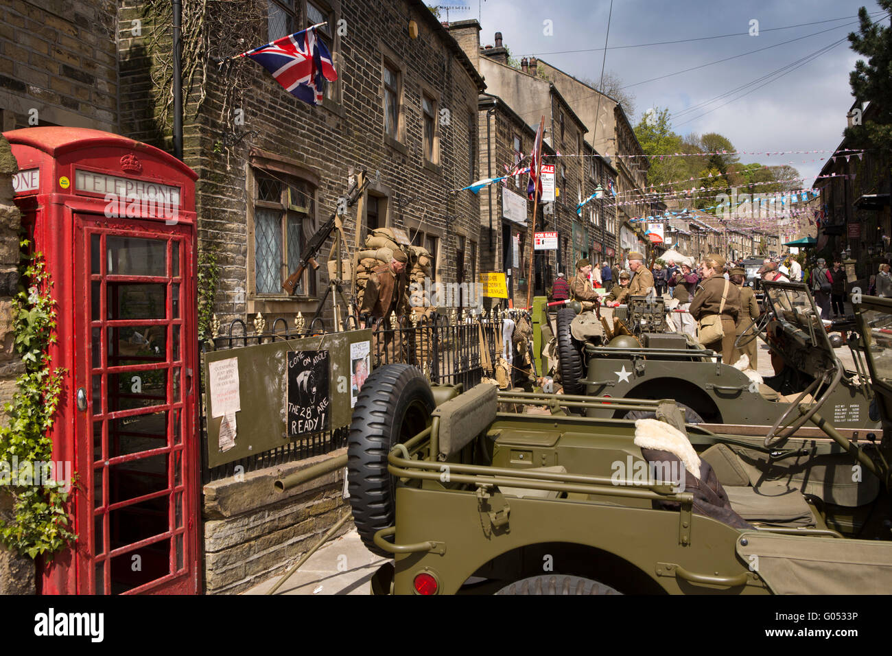 Großbritannien, England, Yorkshire, Haworth 40er Jahre Wochenende, Main Street, Jeeps und Telefon Box d außerhalb der British Home Guard Hauptsitz Stockfoto