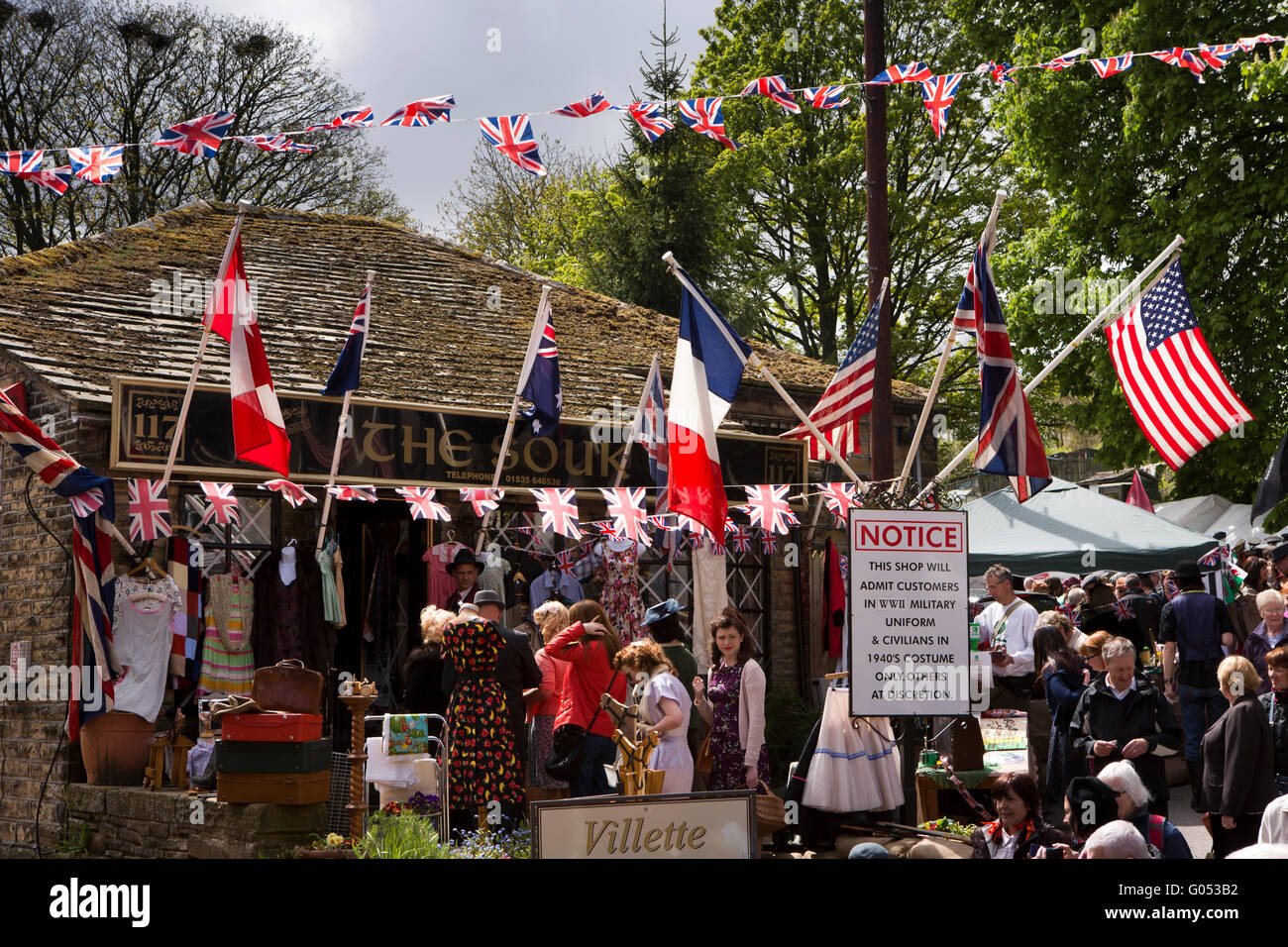 Großbritannien, England, Yorkshire, Haworth 40er Jahre Wochenende, Main Street, Besucher Schlange, um in Souk Vintage Shop bekommen Stockfoto