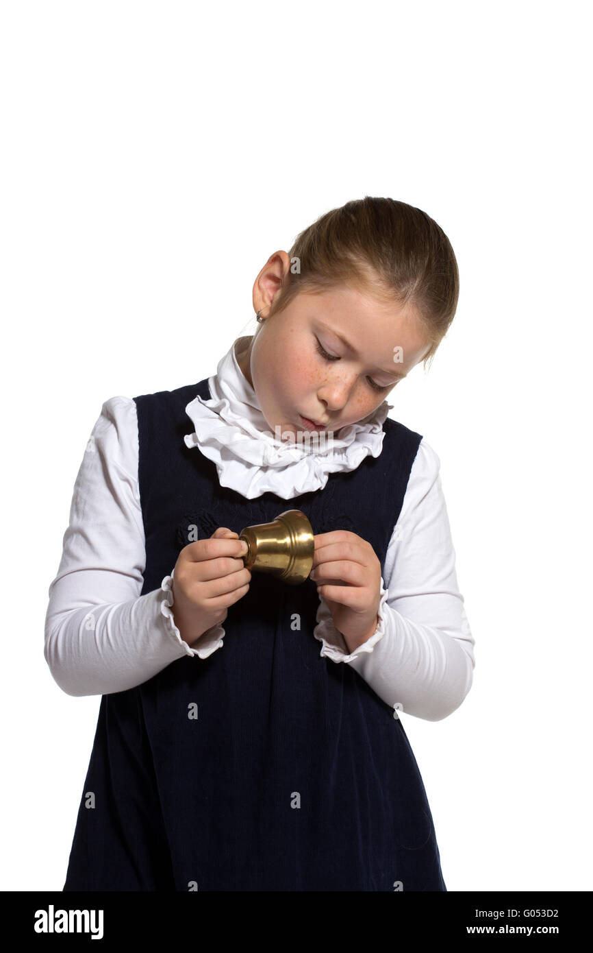 Junge Schulmädchen Blick auf goldene Glocke auf weißem Hintergrund Stockfoto